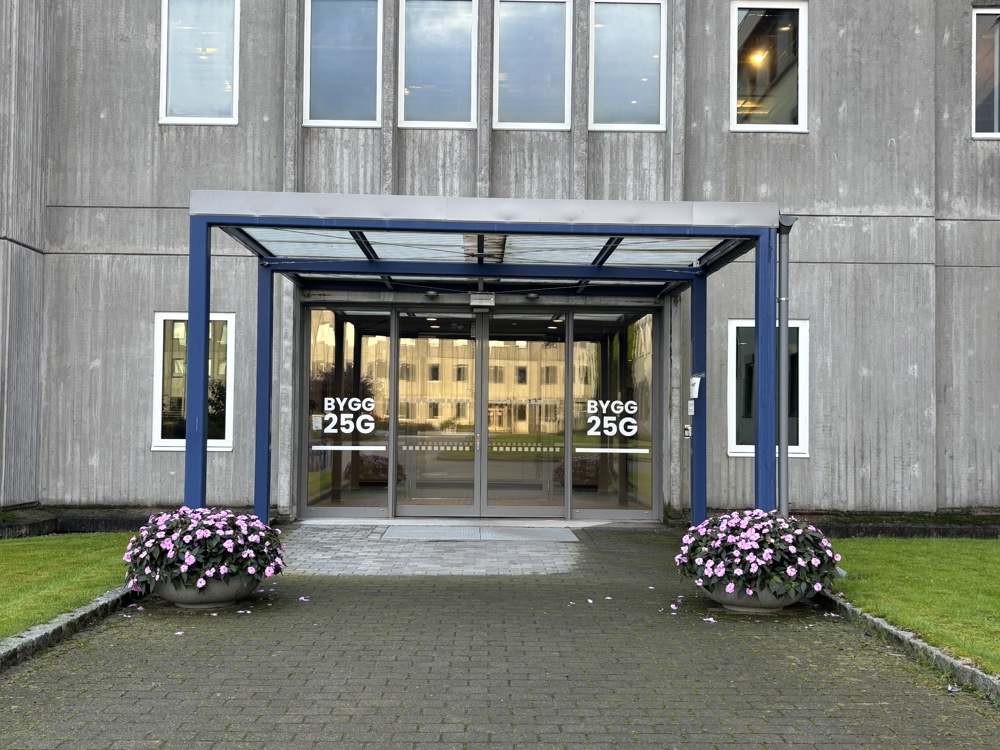 inngangsparti, betongbygg, vinduer, overbygg, blomster i krukker