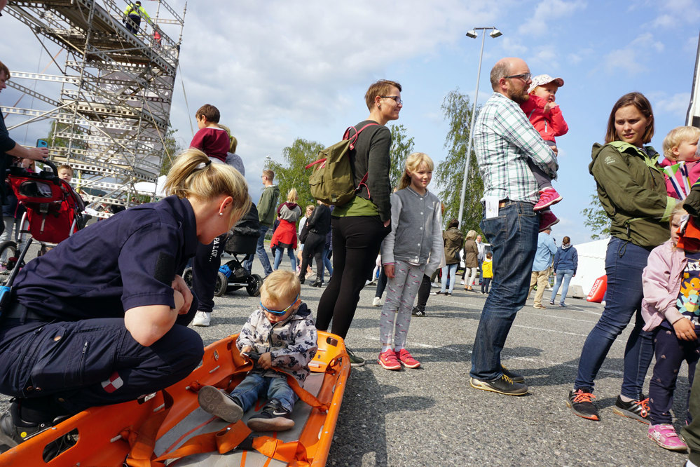 liten gutt får prøve å sitte på båre på bakken