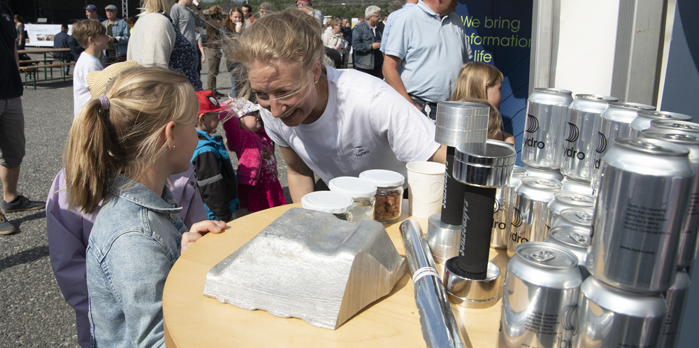 kvinne bøyer seg ned og snakker med småjenter på stand på nabofesten