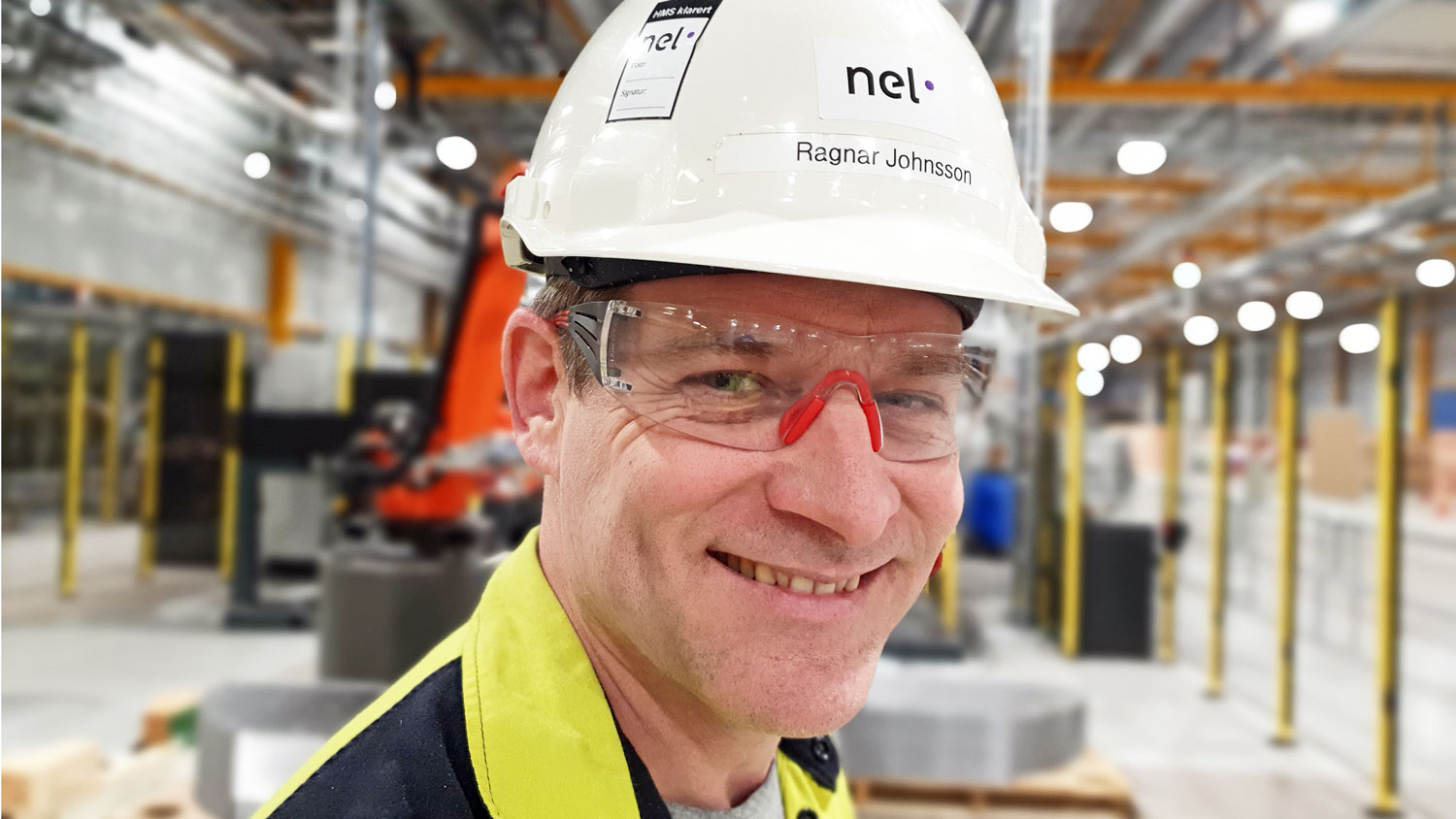 portrait of man, white helmet and goggles, production hall