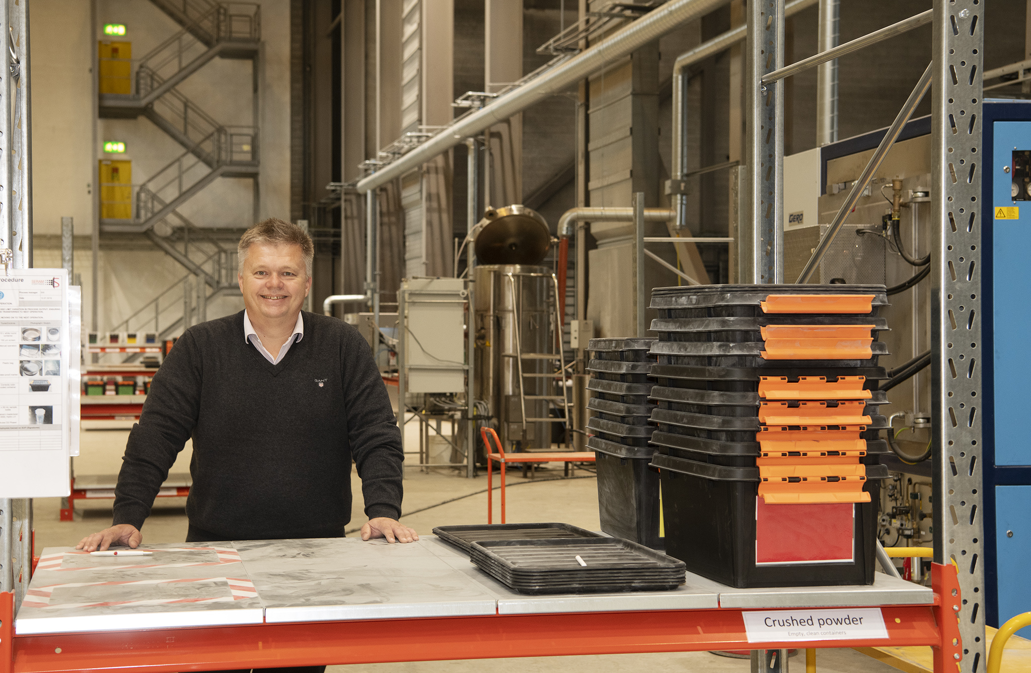 man standing by a desk, production hall