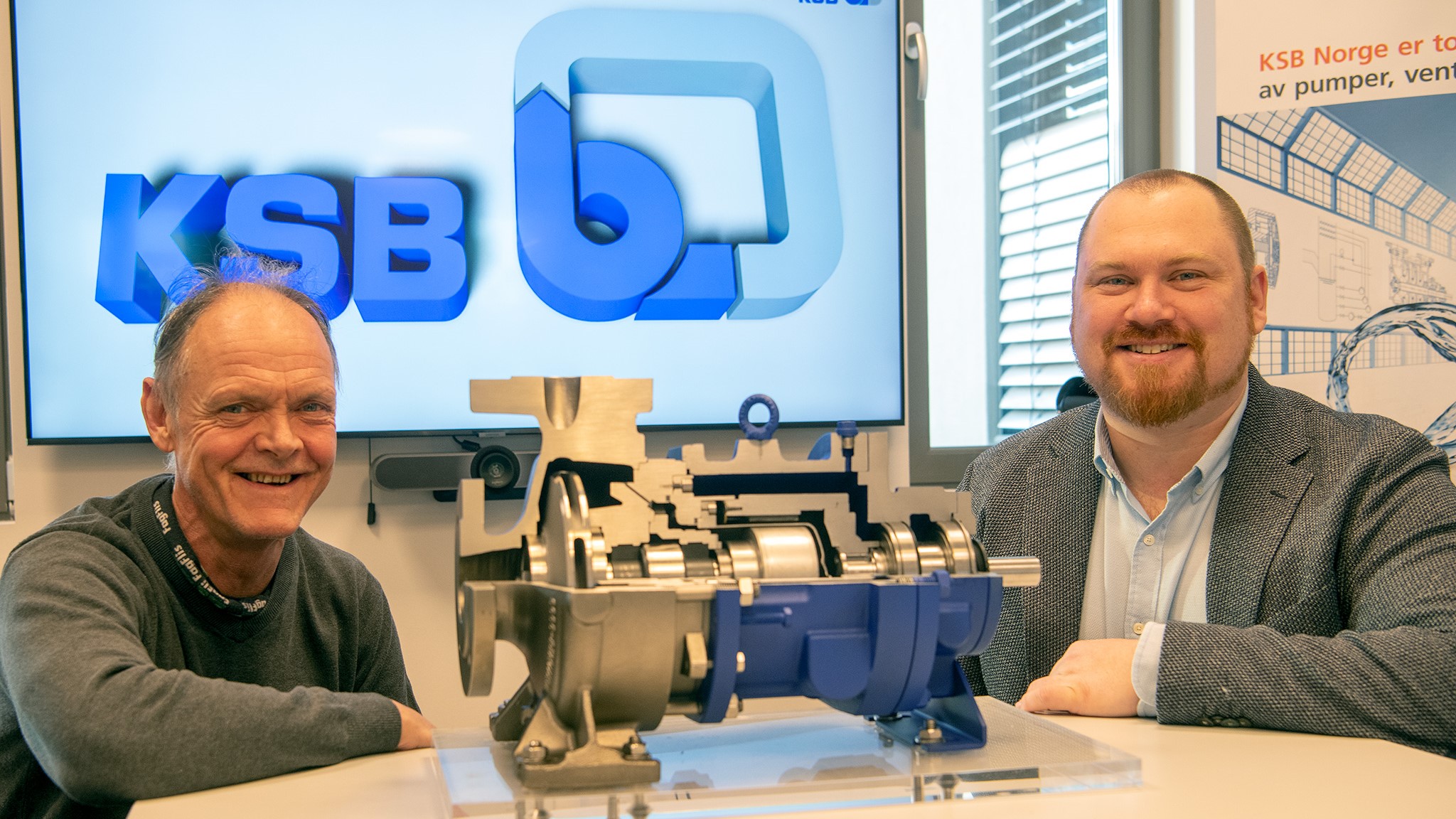 two men sitting at a table, valve in front of them