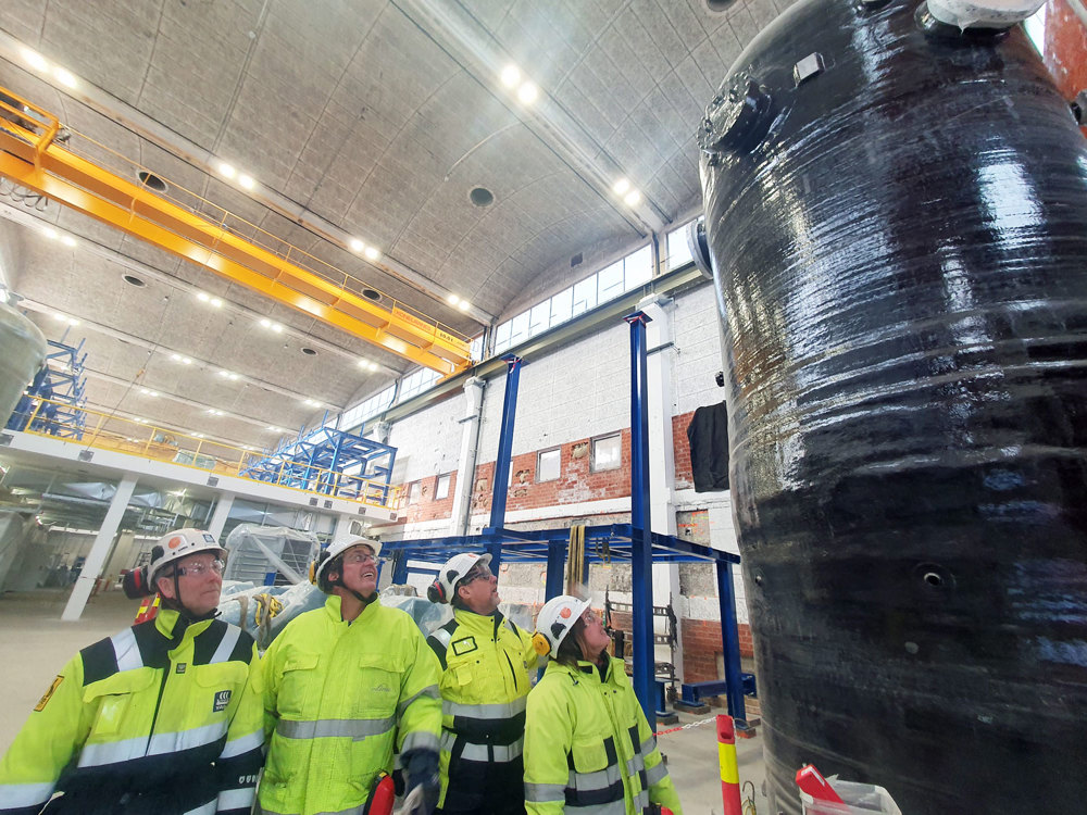 Four people viewing a large oxygen separator