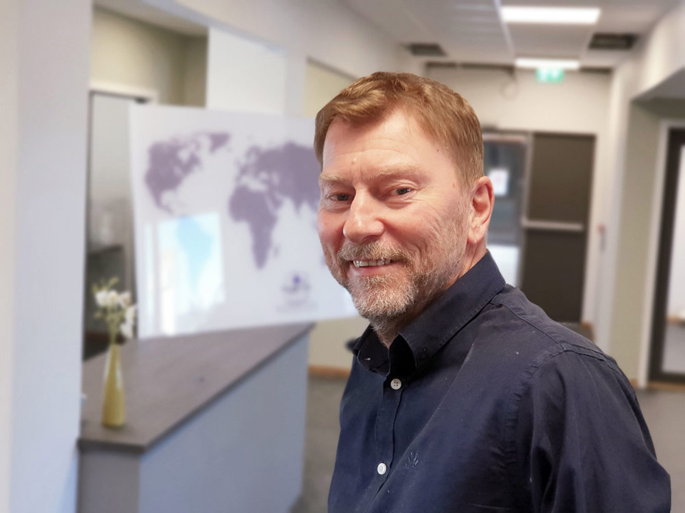 man short hair and beard standing in office space