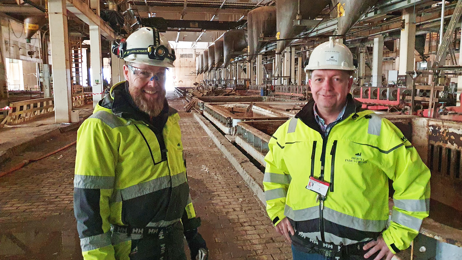 two men wearing personel safety equipment in an old magnesium plant.