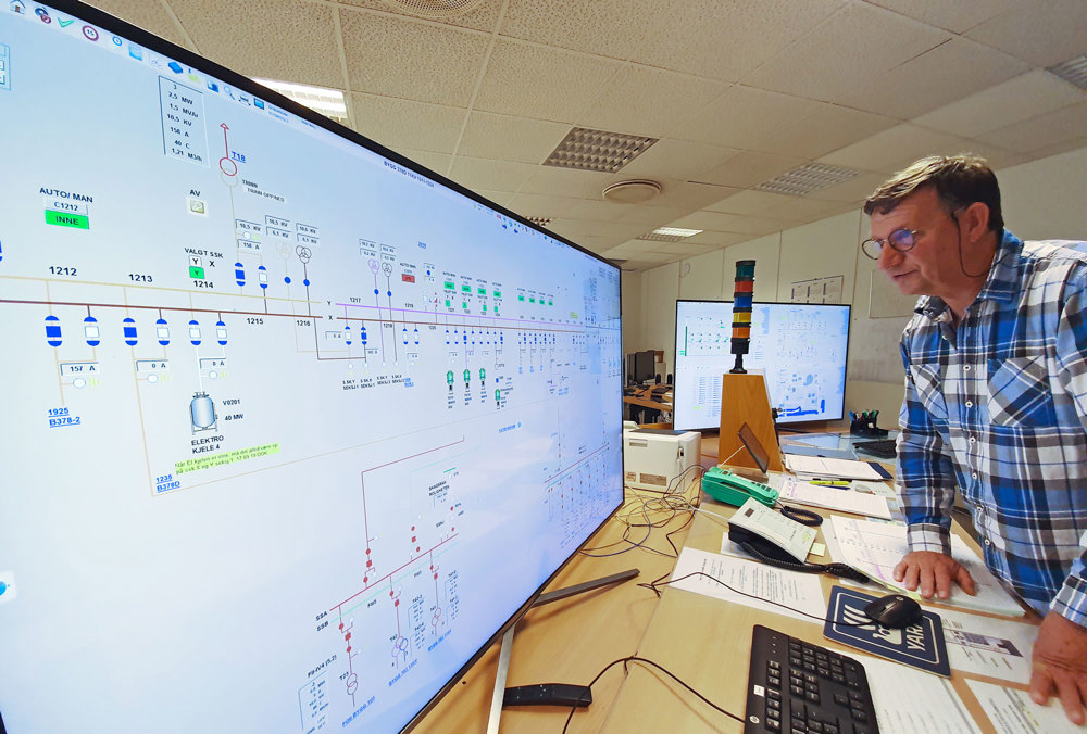 mann står ved kontrollbord og følger med på strømførende punkter
