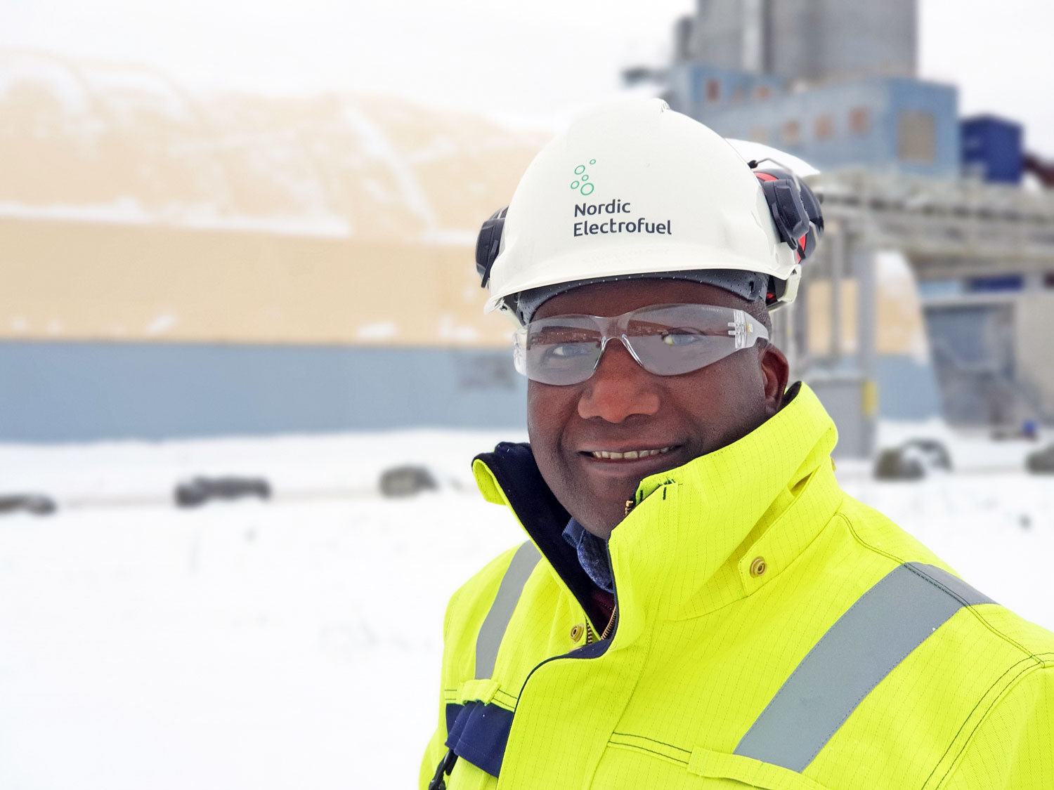 man standing outside in the snow near a plot prepared for new production