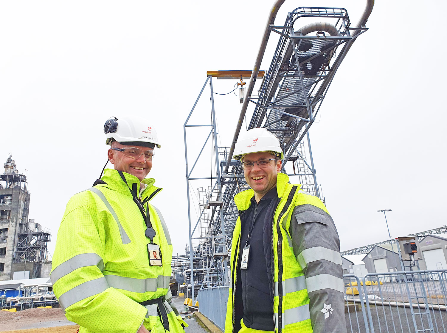 two men, personal protective equipement, posing, in front of test rig