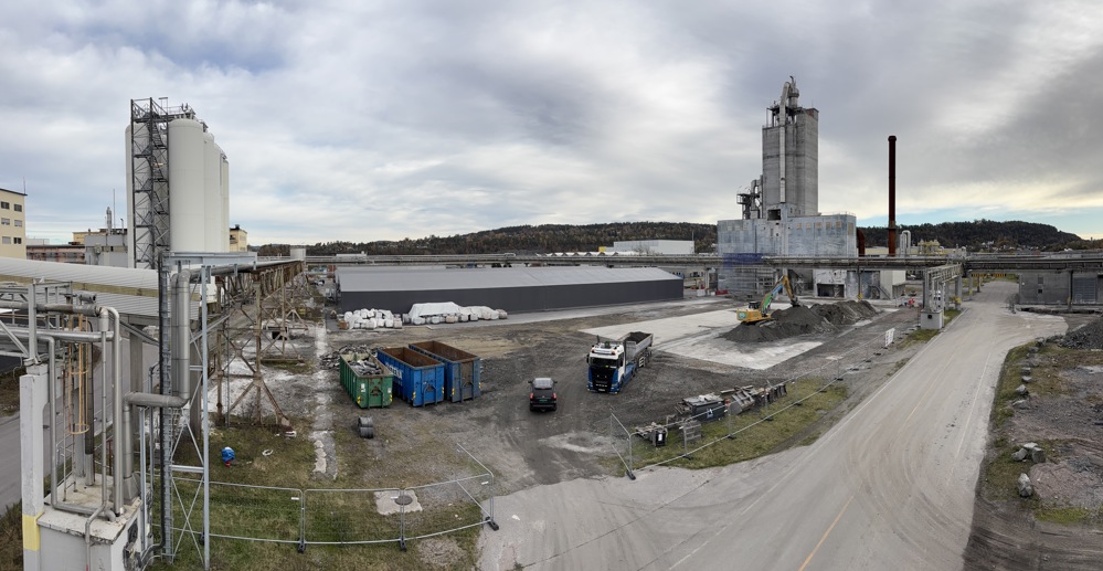 site ready cleared, open space in an industrial park, concrete building in background.