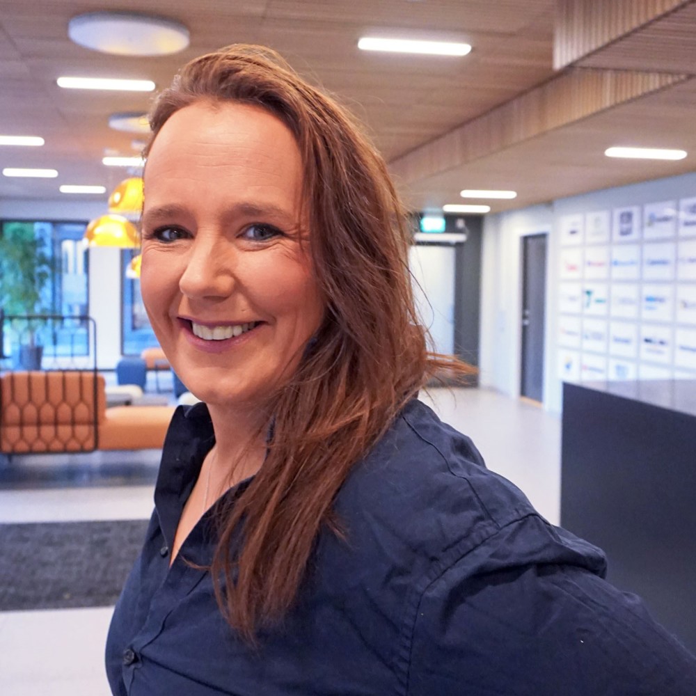 portrait woman, long dark blond hair, smiling, posing, reception area.