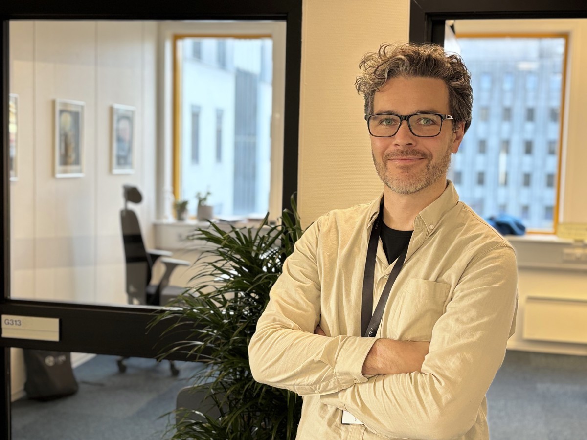 man, posing, arms folded, office environment