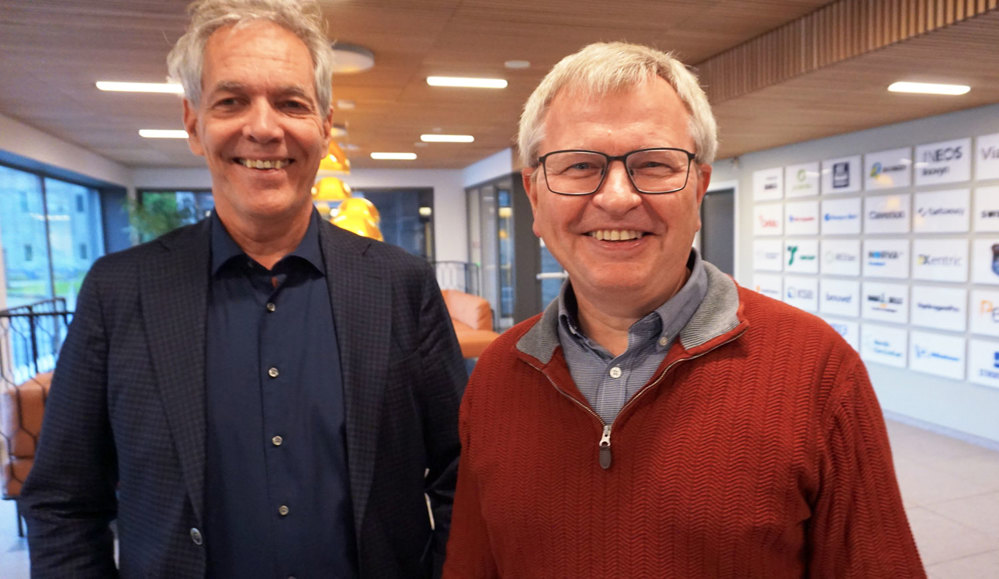 two men standing next to eachother, posing, reception area