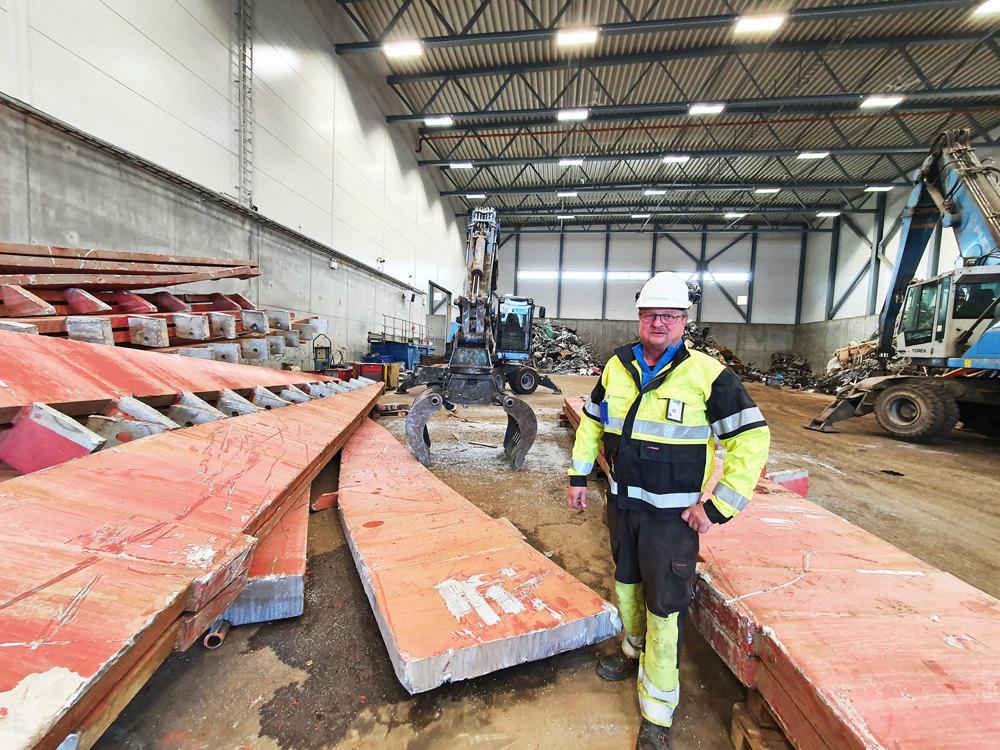 man standing among aluminium rails for recycle