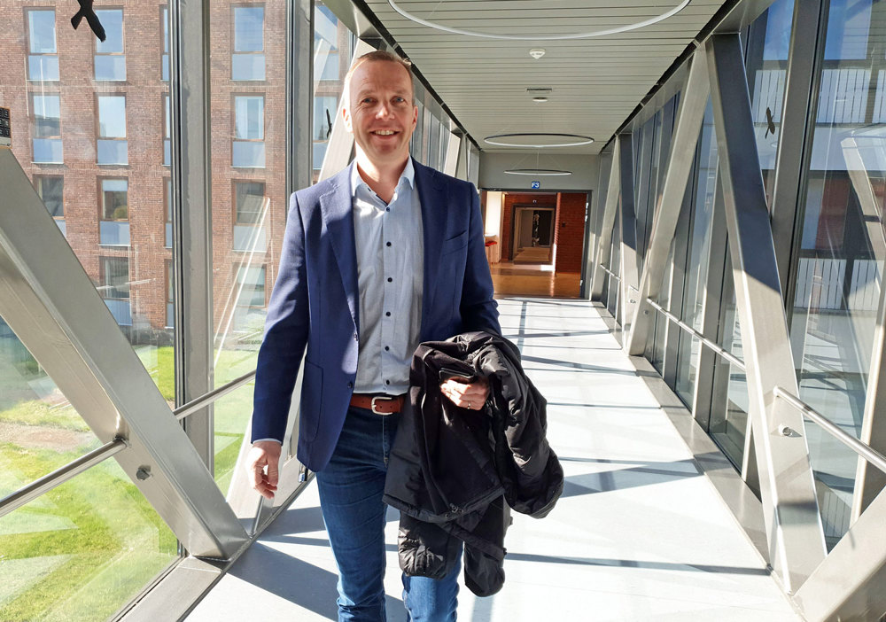 man with carrying coat, walking, corridor, glass walls