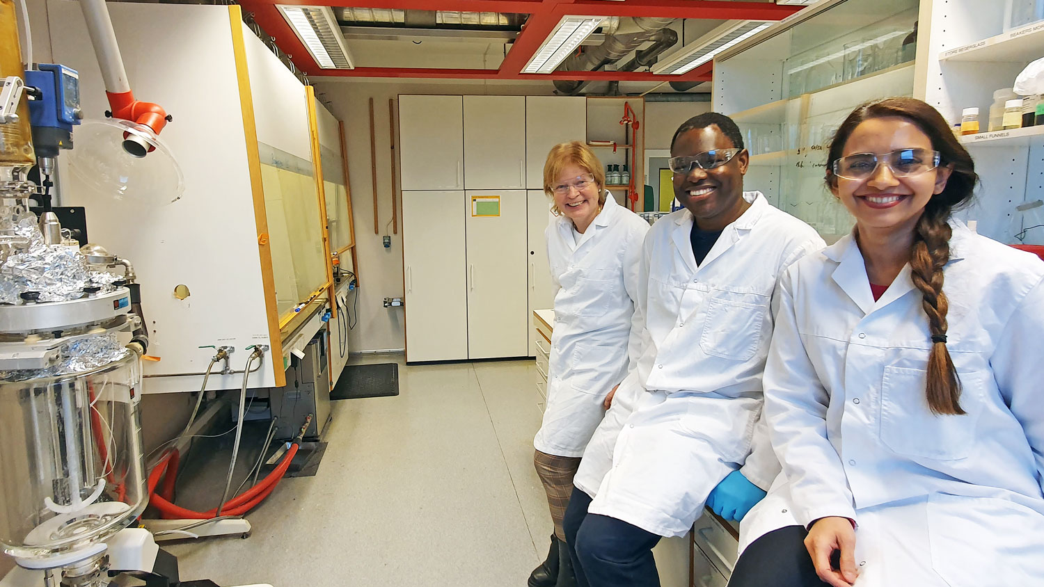 three persons, lab, white coats