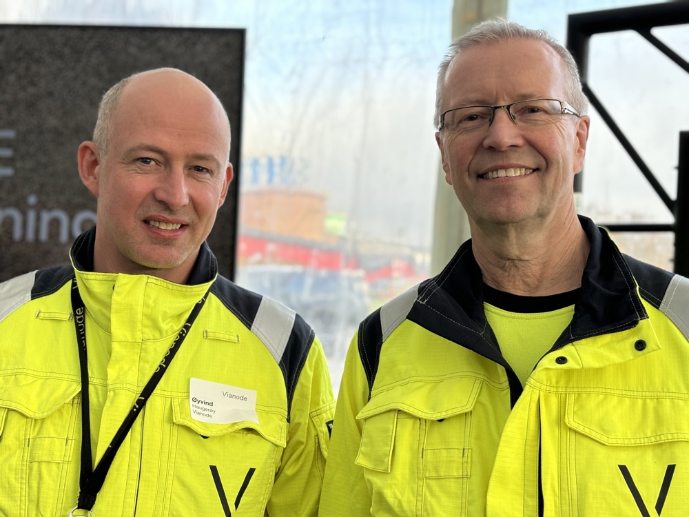 two men, yellow jackets, posing