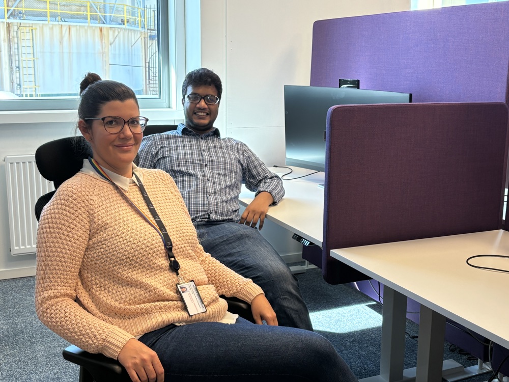 two persons sitting at their desks next to eachother, office, open plan